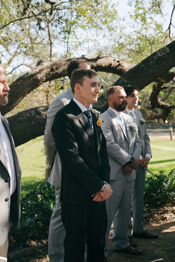 groom watching the bride walk down the aisle 