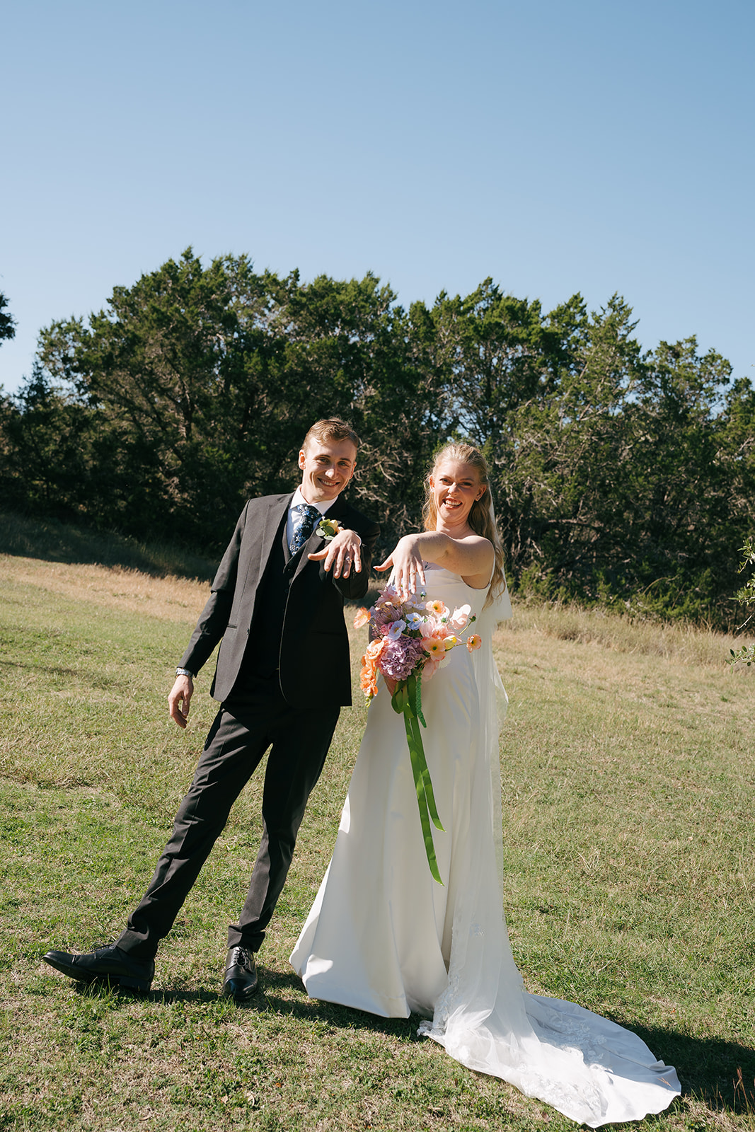 happy newlyweds showing their wedding rings 