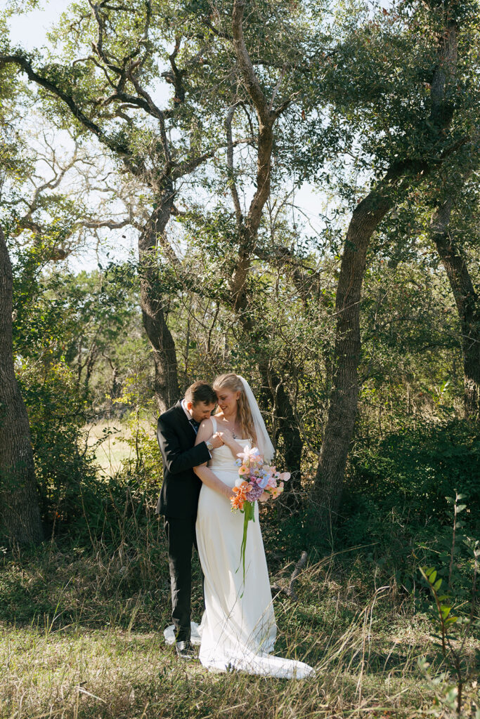 groom kissing the bride on the shoulder 