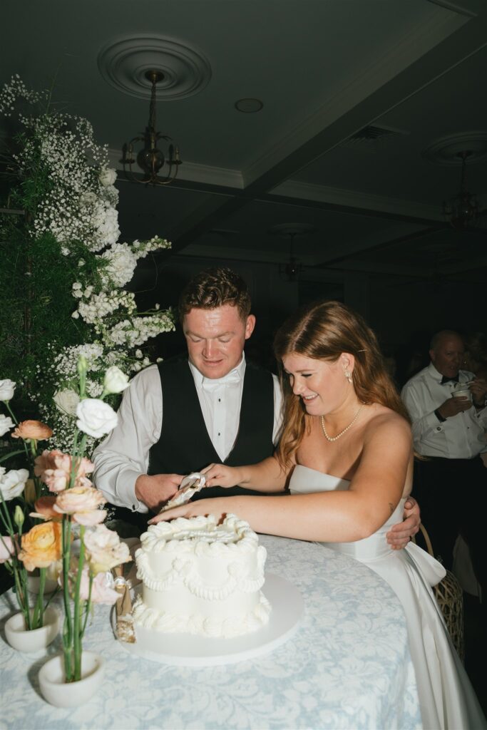 cute couple cutting their wedding cake 