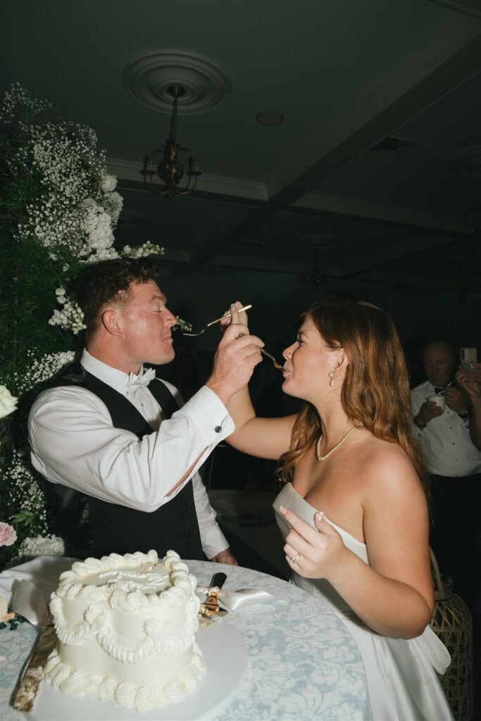 newlyweds trying their wedding cake