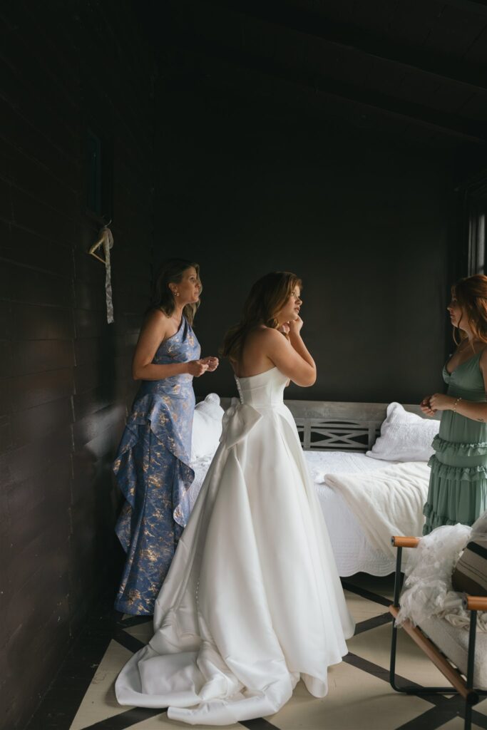 bride putting on her jewelry for her wedding