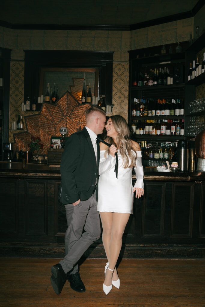 pulling partner close at a nashville bar for engagement photos 