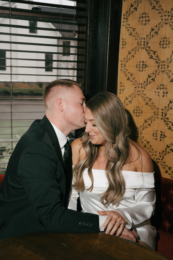 intimate close up of couple at nashville bar whispering in each other's ear 