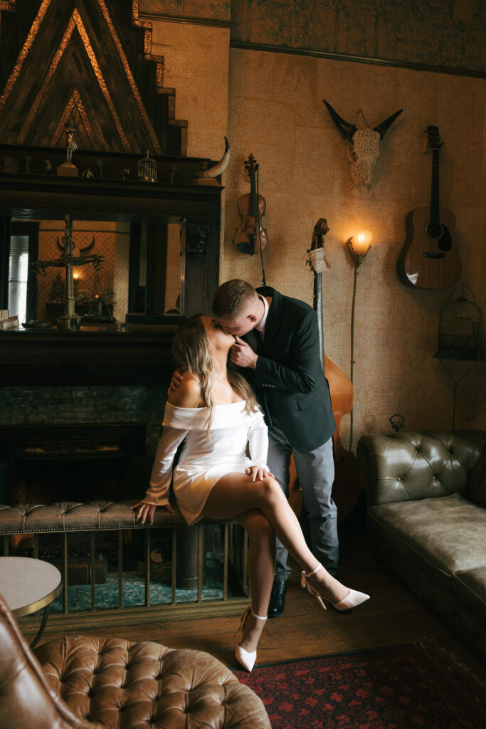couple kissing in moody lighting at a Western themed bar 