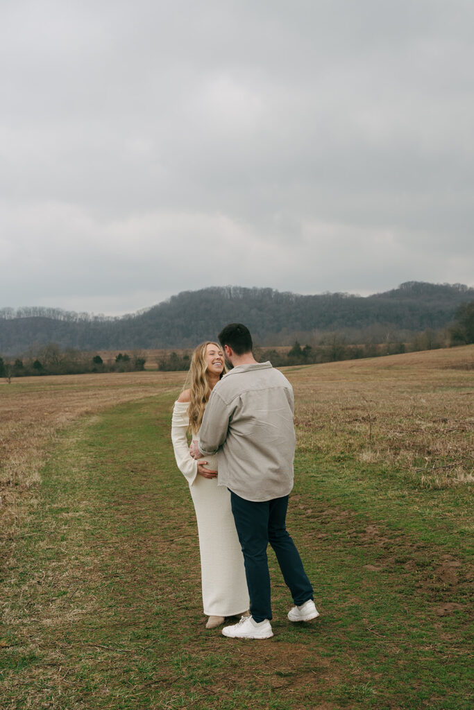 couple smiling at each other during maternity photoshoot in nashville 
