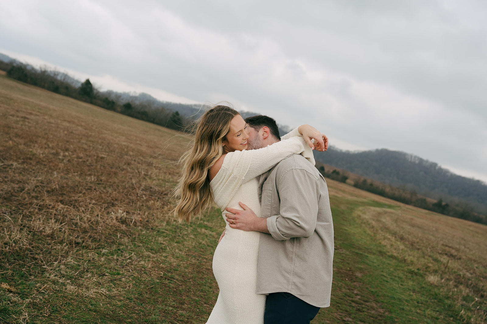 couple hugging at maternity photoshoot outside in winter