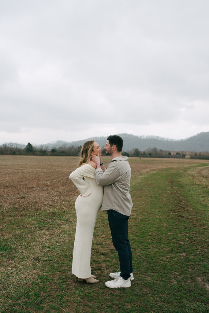 couples maternity photoshoot at a field in Nashville leaning in to kiss