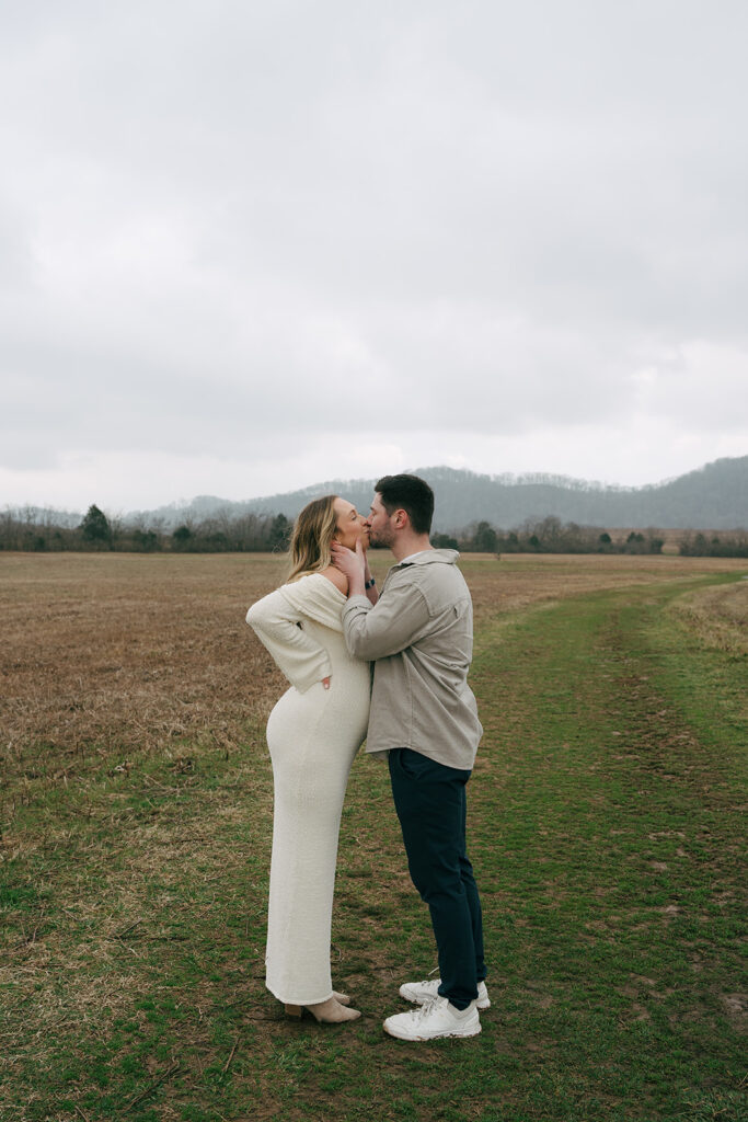 couple taking maternity photos at bells bend  kissing
