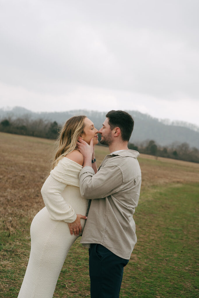 couple kissing at outdoormaternity photoshoot 