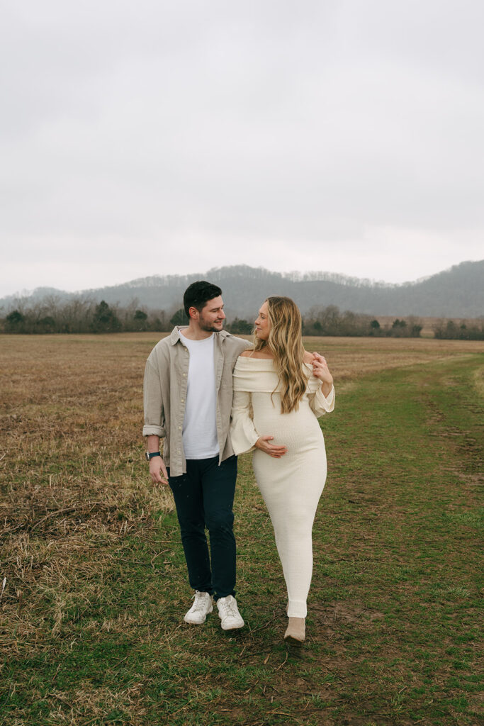maternity couple with arms around each other 