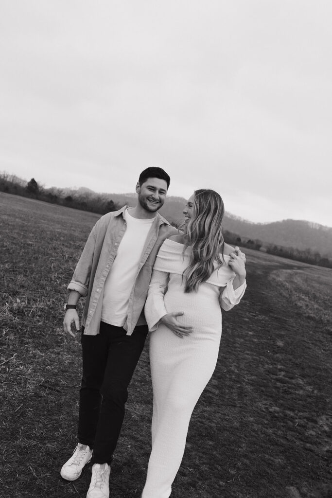 maternity couple casually walking holding baby bump