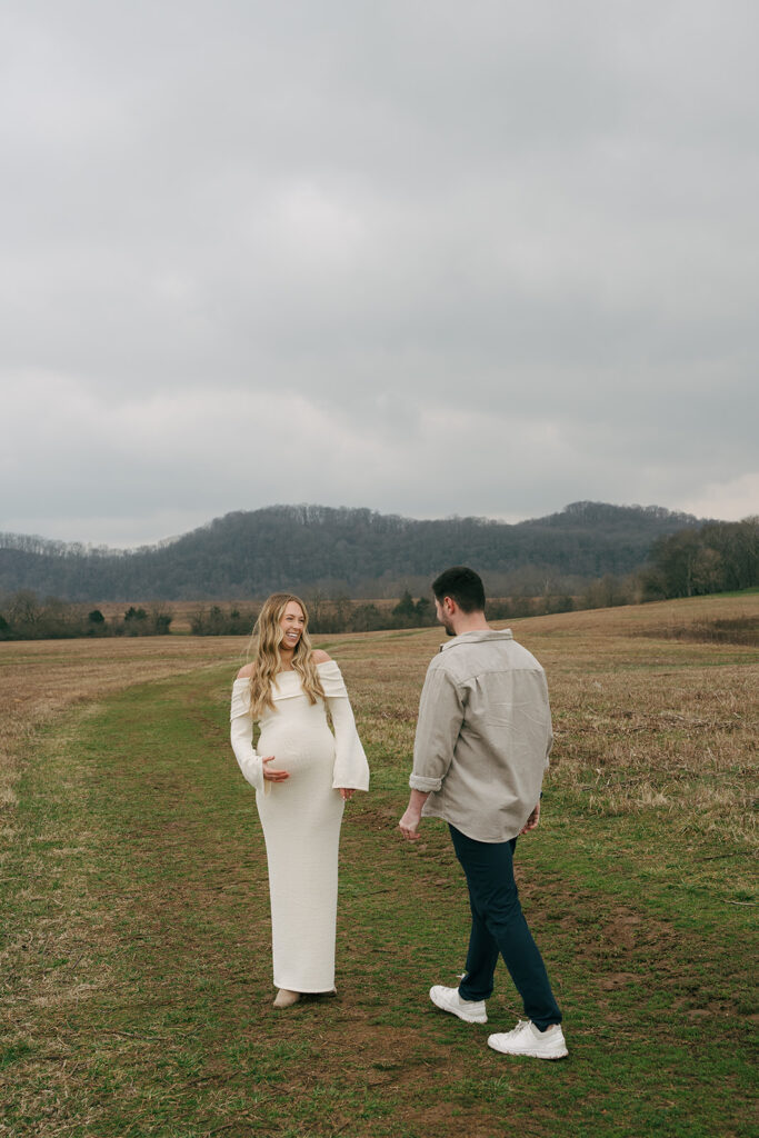 maternity couple at photoshoot looking at each other 