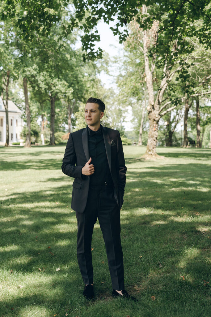 groom in all black editorial pose 