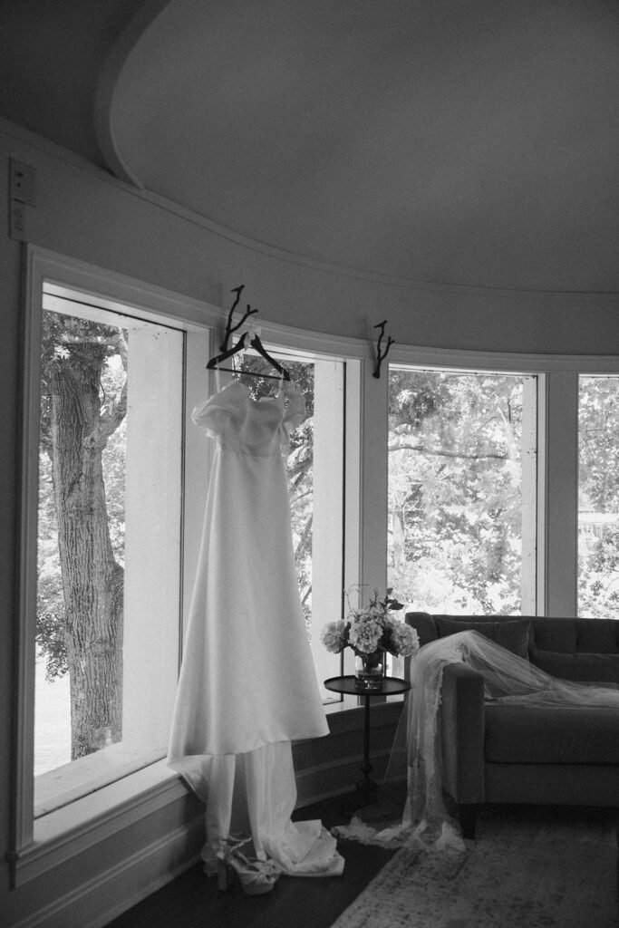 black and white wedding gown hung in window