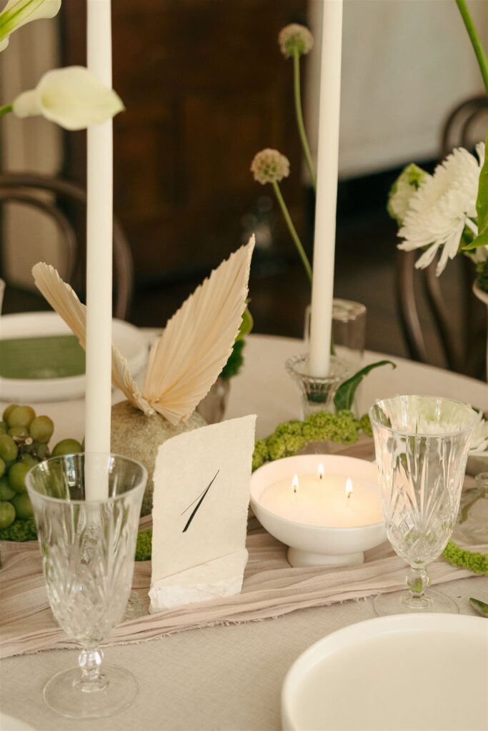 wedding table decor with lit candle and table number 