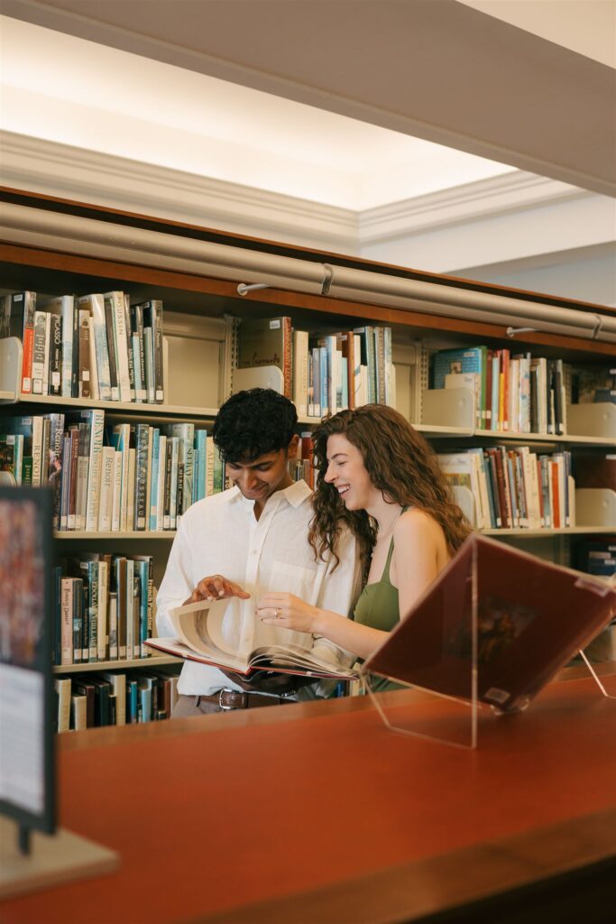 couple flipping through a book together and laughing 