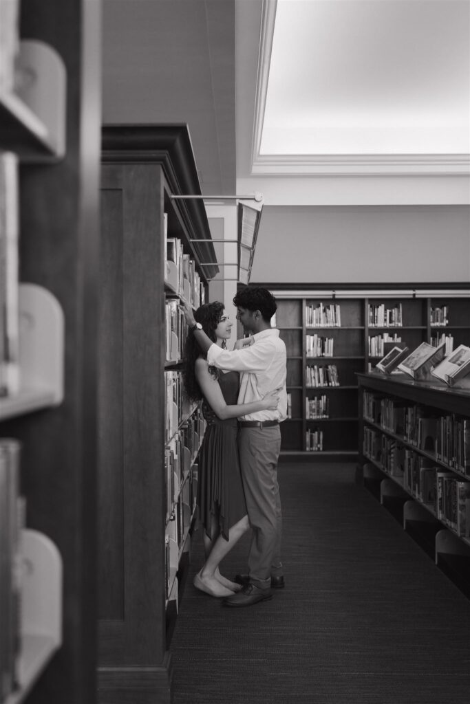 couple in a library stealing a moment among the shelves of books 