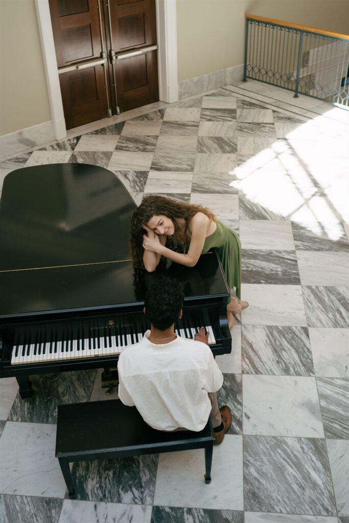 woman looking lovingly at her partner playing the piano at the Nashville public library with marble floors 