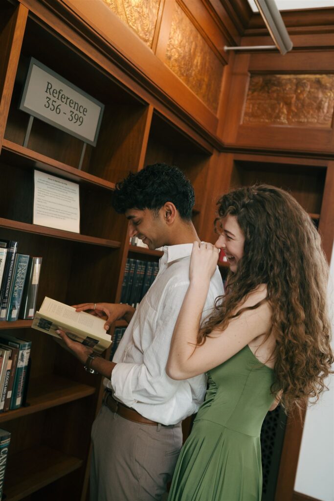 couple laughing and looking at books together at a public library 