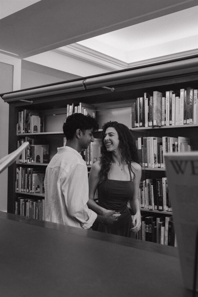 couple laughing and having a candid moment at a library 