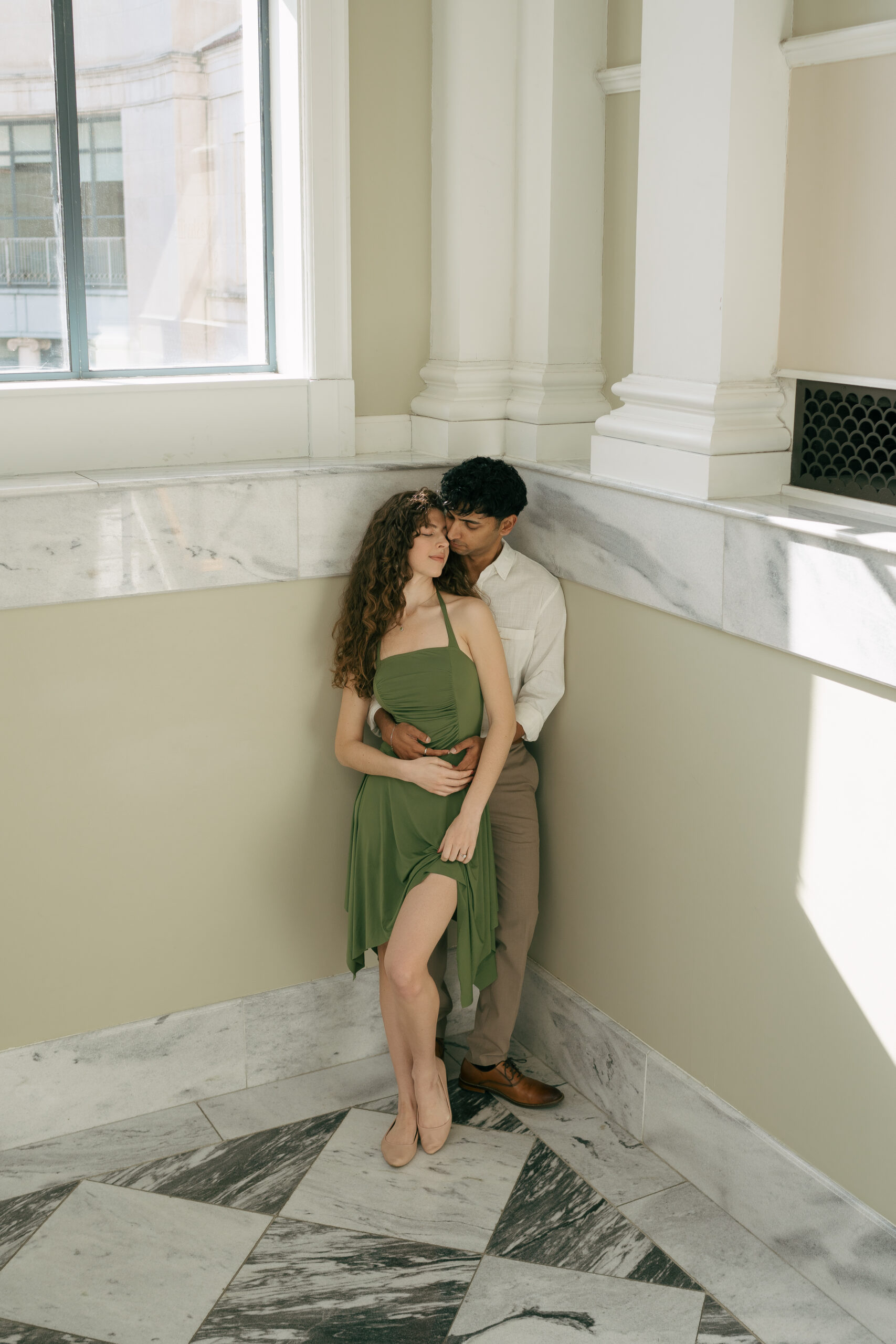 engaged couple in a library holding onto eachother