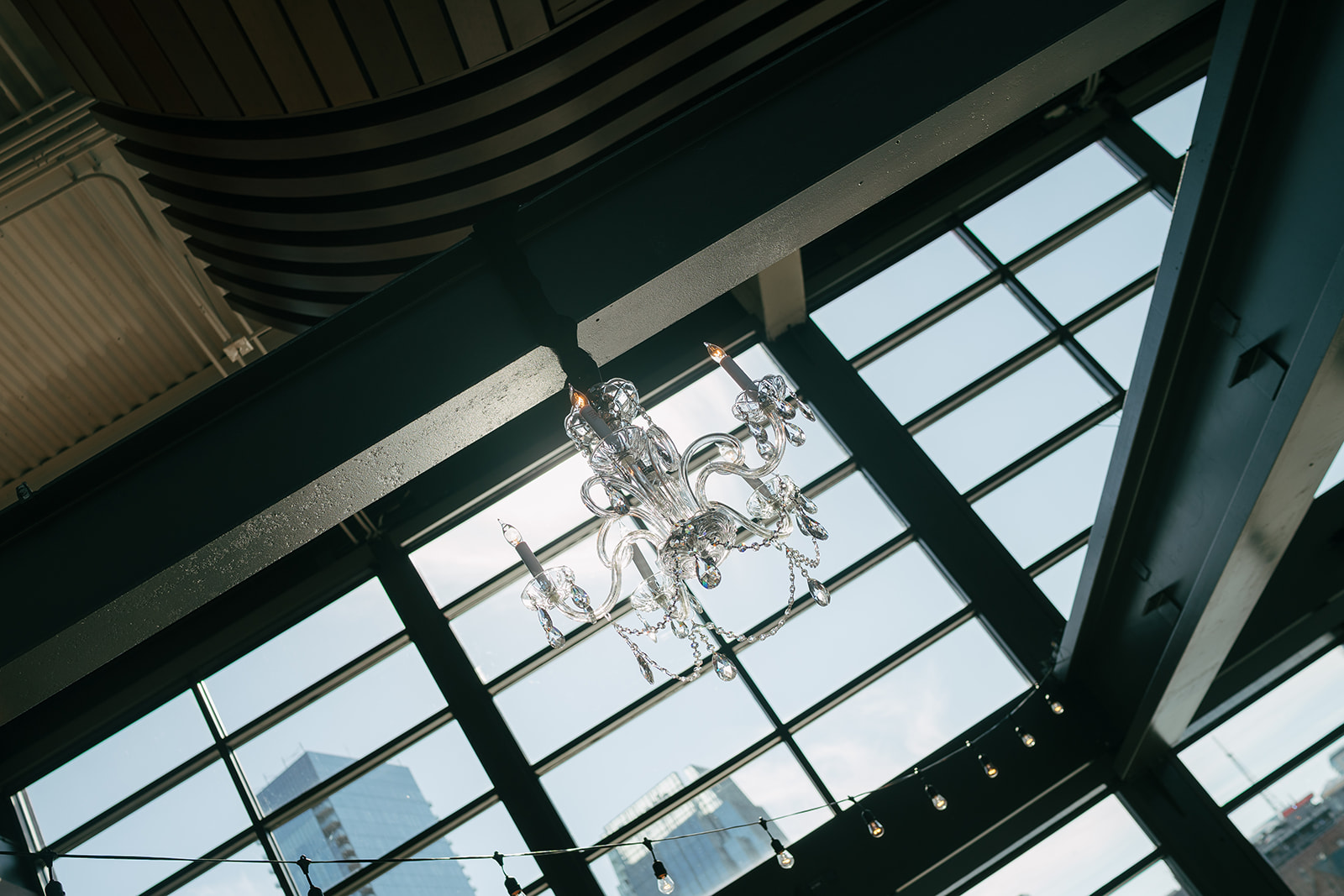 large window with natural light shining through featuring a crystal chandelier